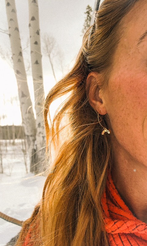 Close-up of a person with long hair and an orange scarf in a snowy landscape.